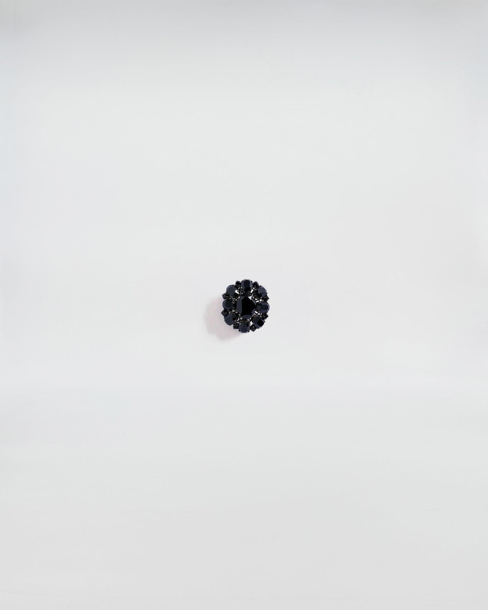 SPILLA IN STRASS FIORE MEDIO in black stone, featuring a classic design with a modern touch, showcased on a white background.
