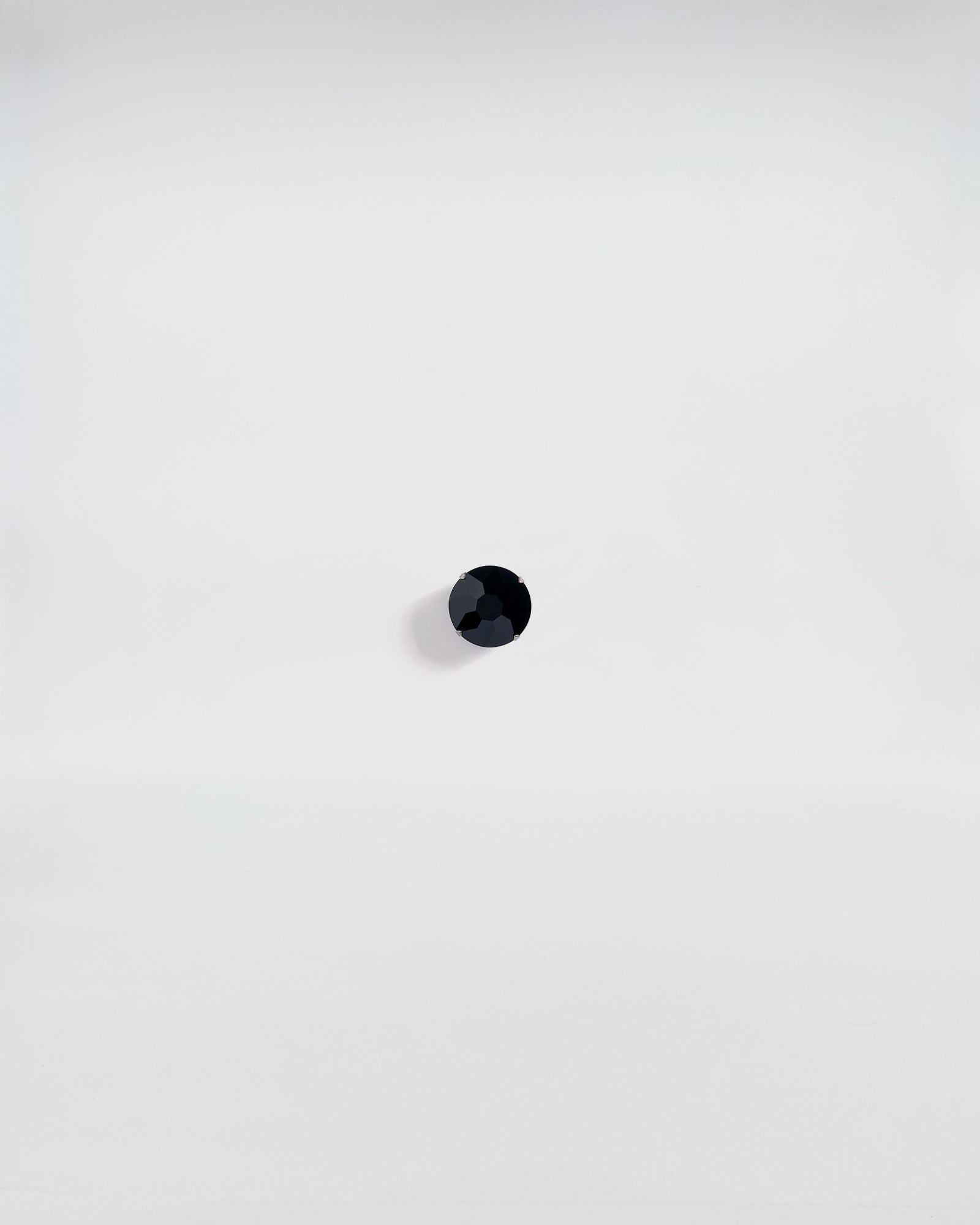SPILLA MAXI ROUND, black stone brooch, modern and classic design, with gunmetal finish, showcased on a white background.